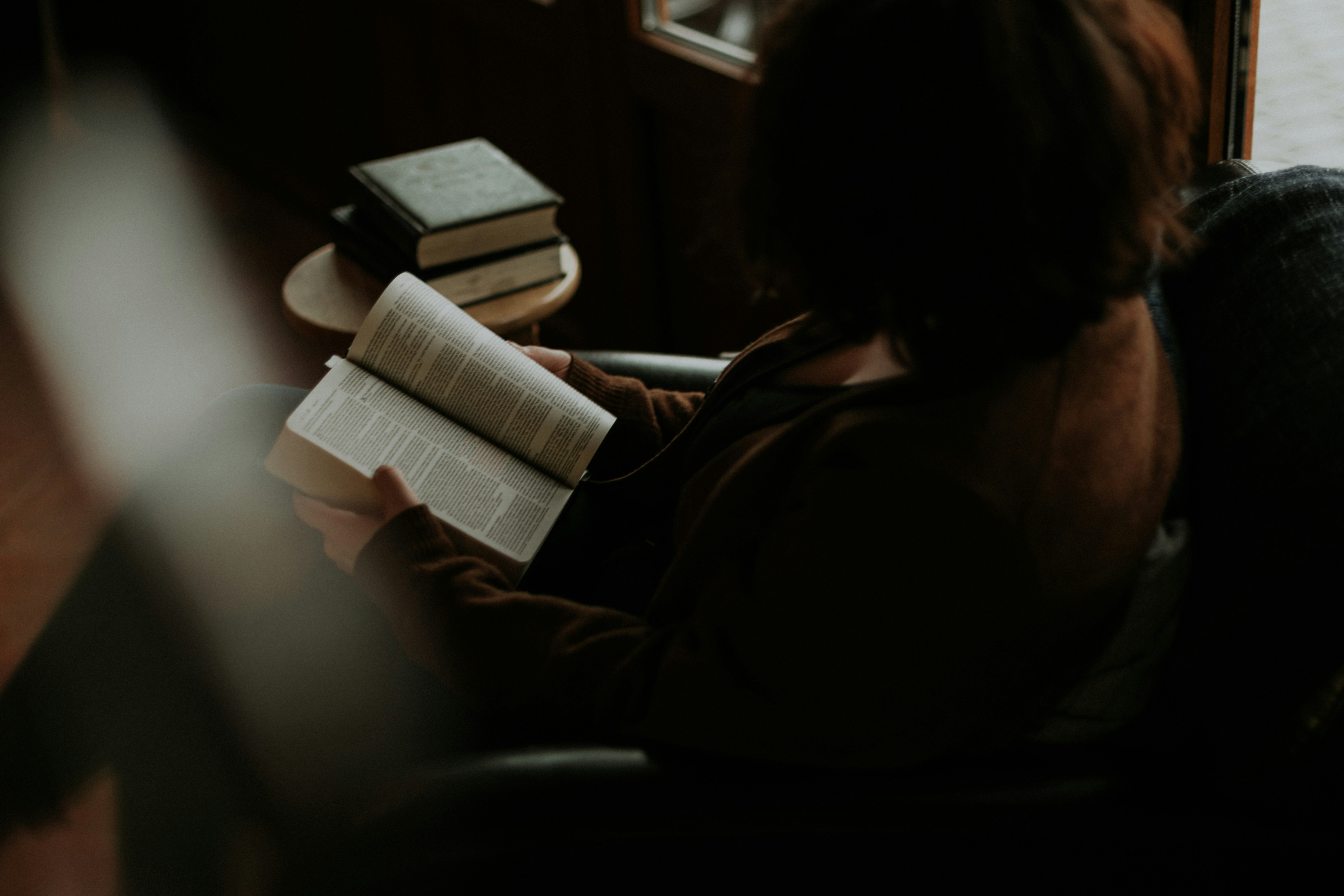 woman reading book on sofa