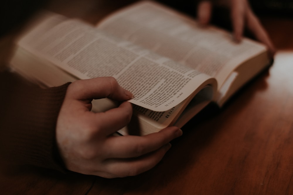 person holding white book page