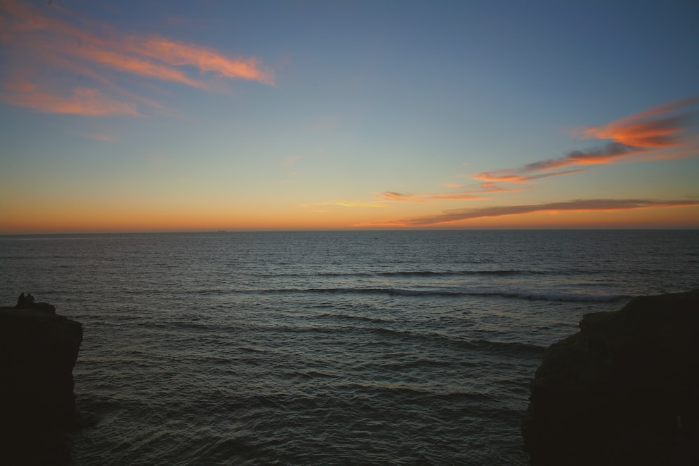 body of water under blue sky during sunset