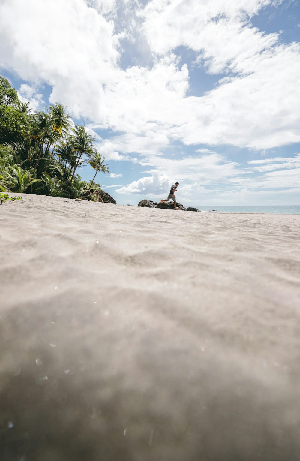 person sitting on rock near body of water during daytime