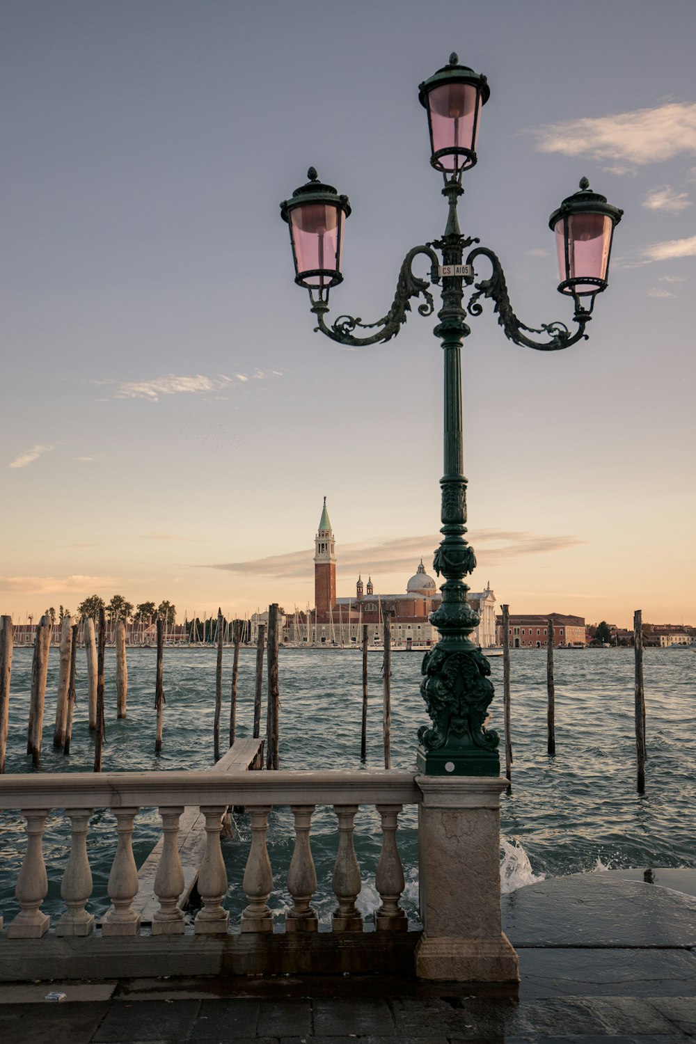 black street light near body of water during sunset