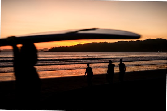 silhouette of 3 people standing on seashore during sunset in Playa Venao Panama