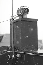 A professional technician installing roof heat cables on a snowy roof.