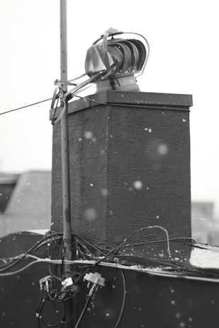 A professional technician installing roof heat cables on a snowy roof.