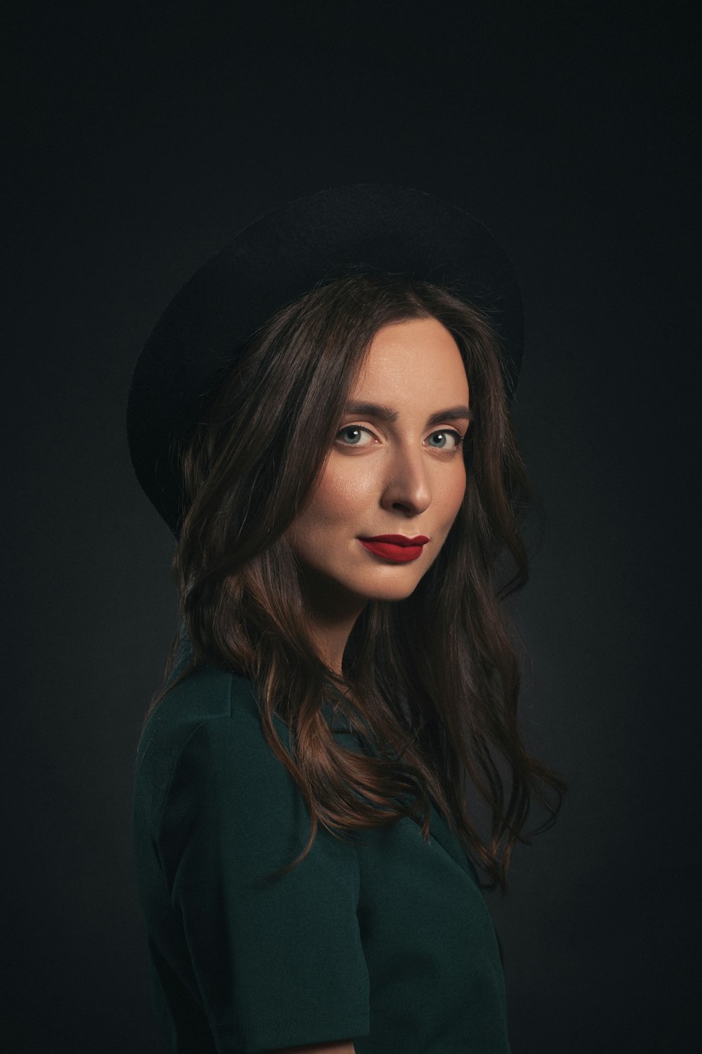 Femme au chapeau noir et chemise verte