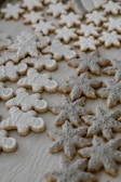 Assorted decorated cookies with soft pastel icing, displayed on a light wooden board.