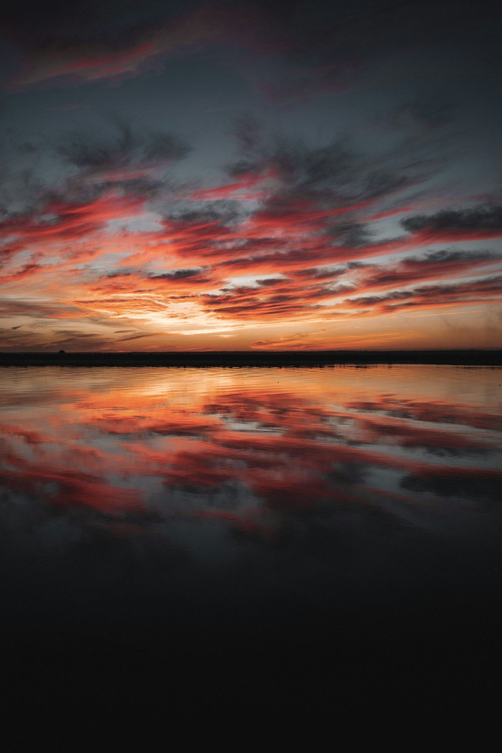 Plan d’eau sous ciel nuageux au coucher du soleil