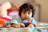 child in blue long sleeve shirt lying on bed