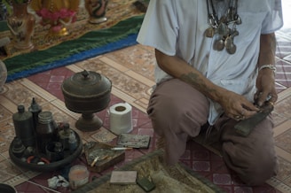 man in white button up t-shirt and brown pants sitting on floor