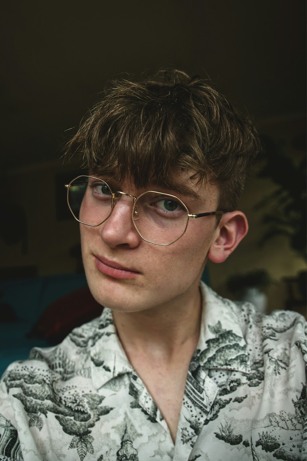 man in gray and white floral button up shirt wearing eyeglasses