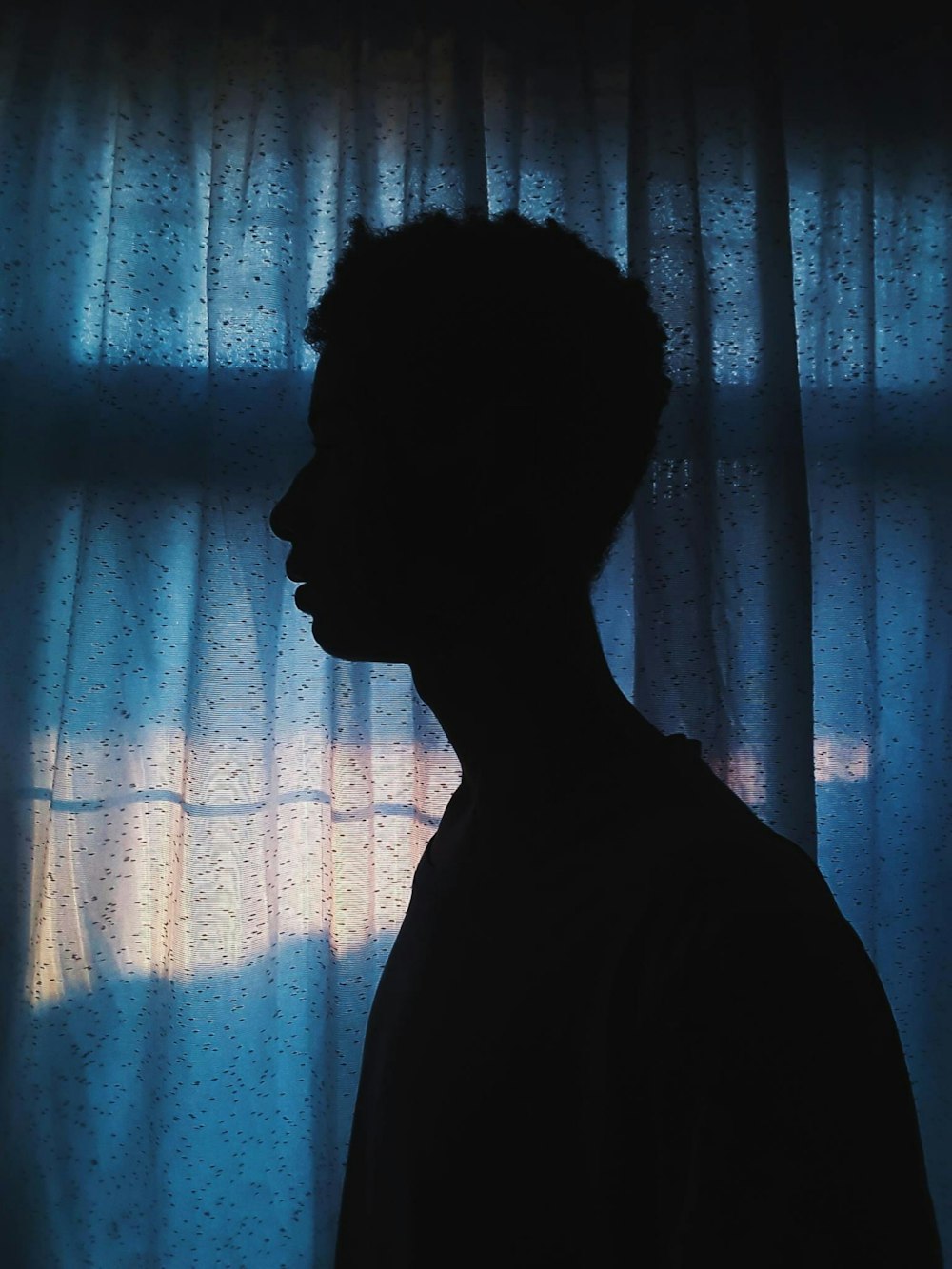 silhouette of man standing near window