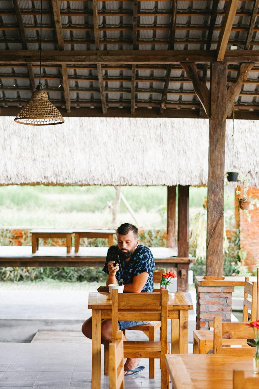 woman in black and white polka dot shirt sitting on brown wooden chair