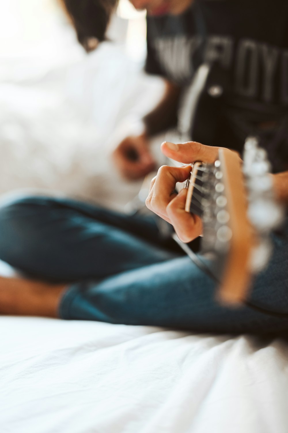 person in blue denim jeans sitting on bed