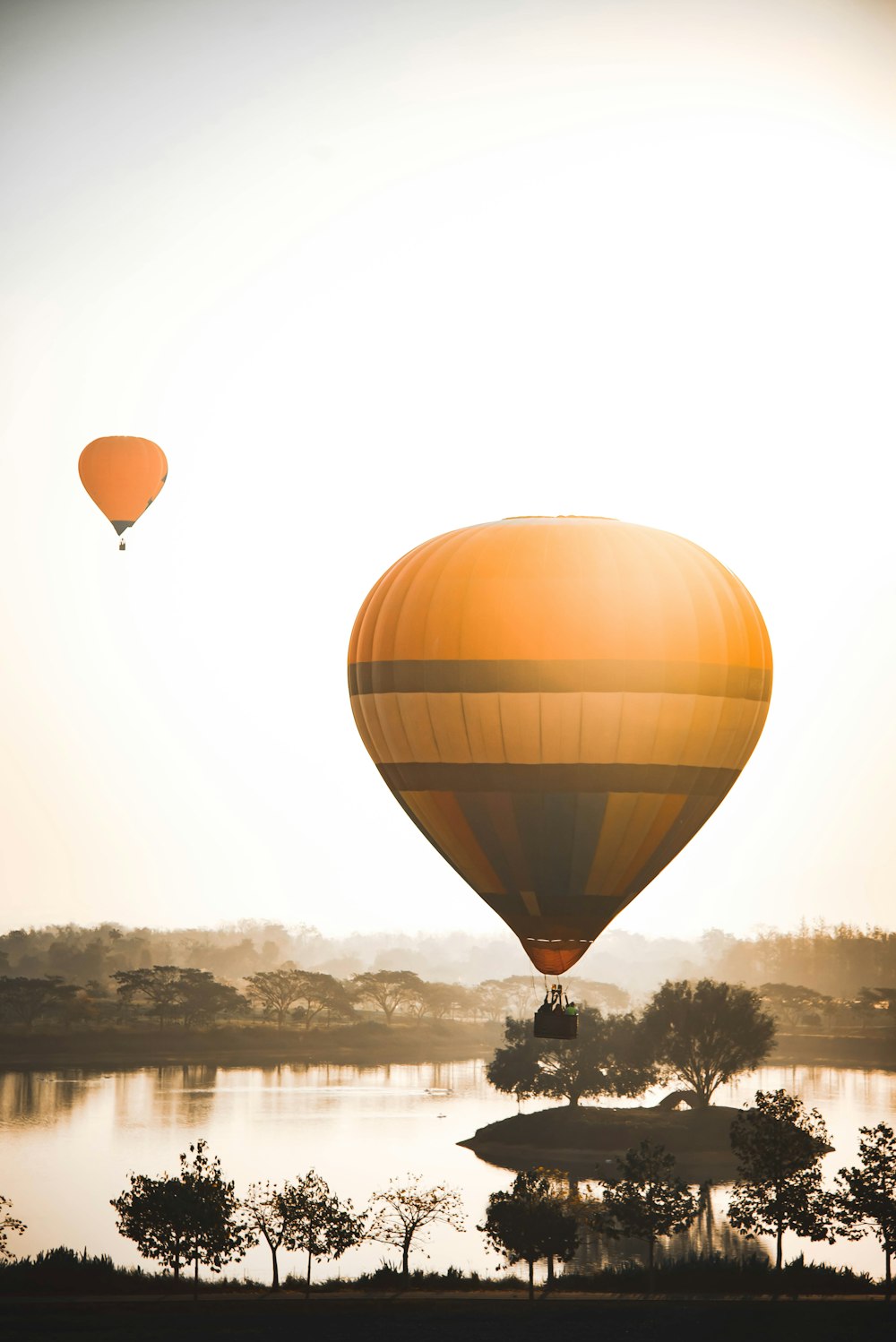 brown hot air balloon floating on water during daytime