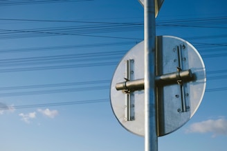 Close-up of a sturdy, freshly installed sign post with a clear blue sky background.