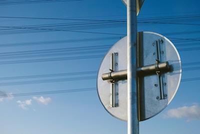Close-up of a sturdy, freshly installed sign post with a clear blue sky background.