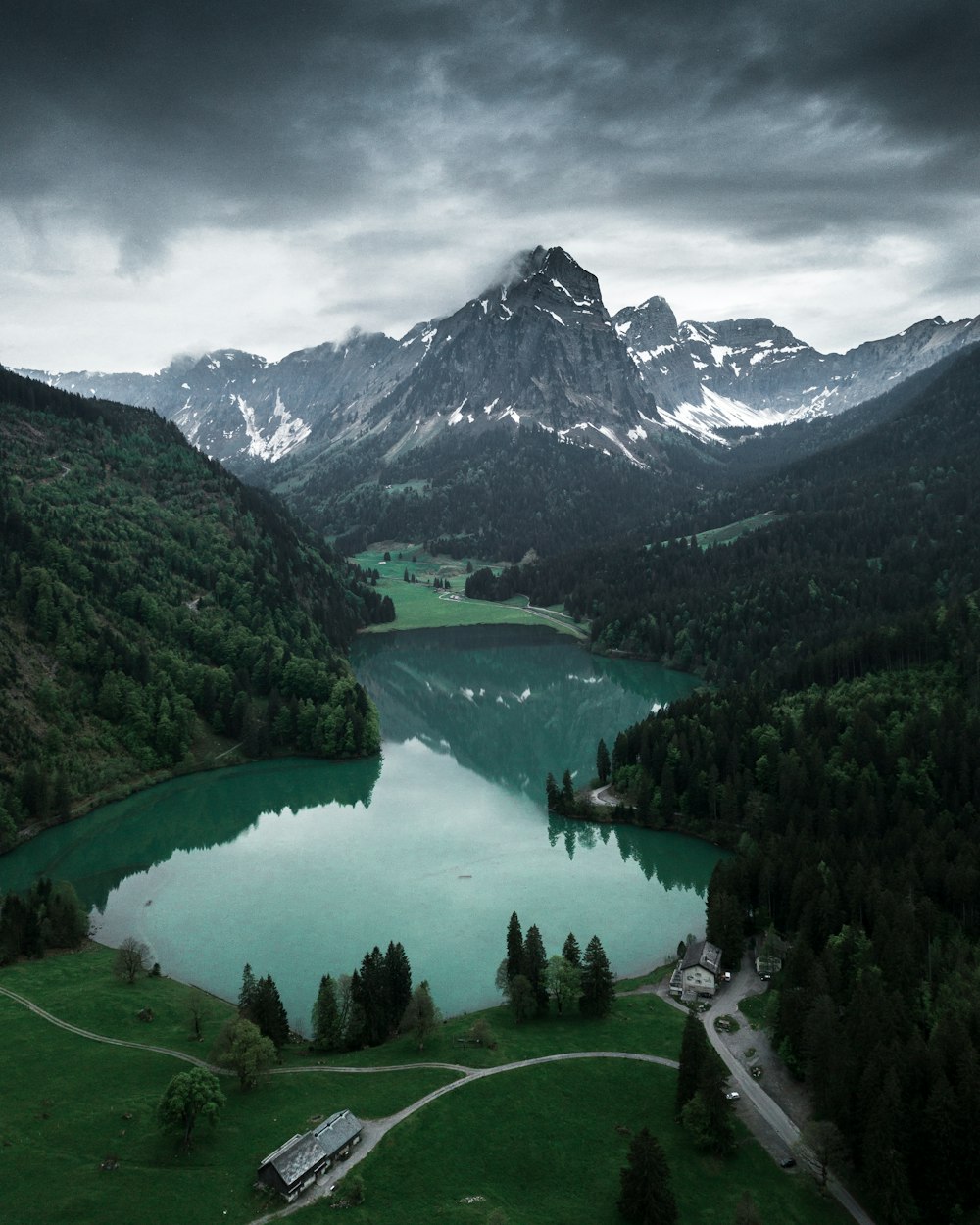 lake in the middle of green trees and mountains