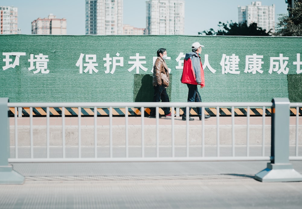 2 women standing on gray concrete road during daytime