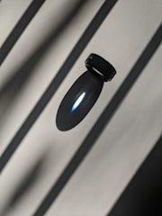 A sleek platinum ring with a modern design displayed on a reflective black surface.