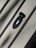 A close-up of a sleek black ring resting on a wooden surface.