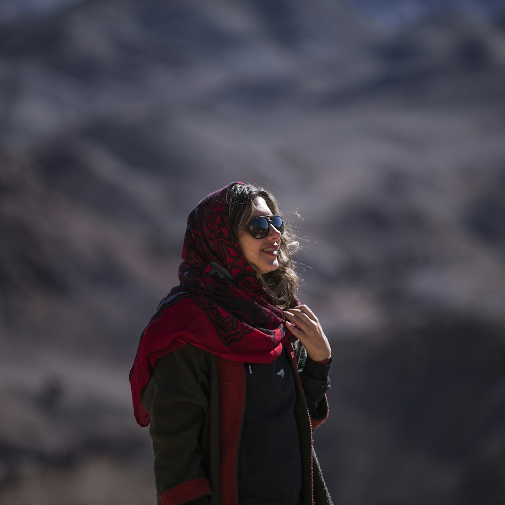 woman in red and black jacket wearing black and white mask