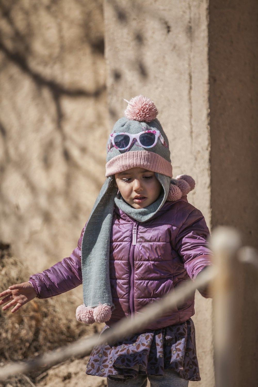 girl in purple and pink knit cap and purple jacket