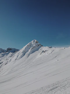 A serene close-up of a glistening ice mountain peak under a clear blue sky.