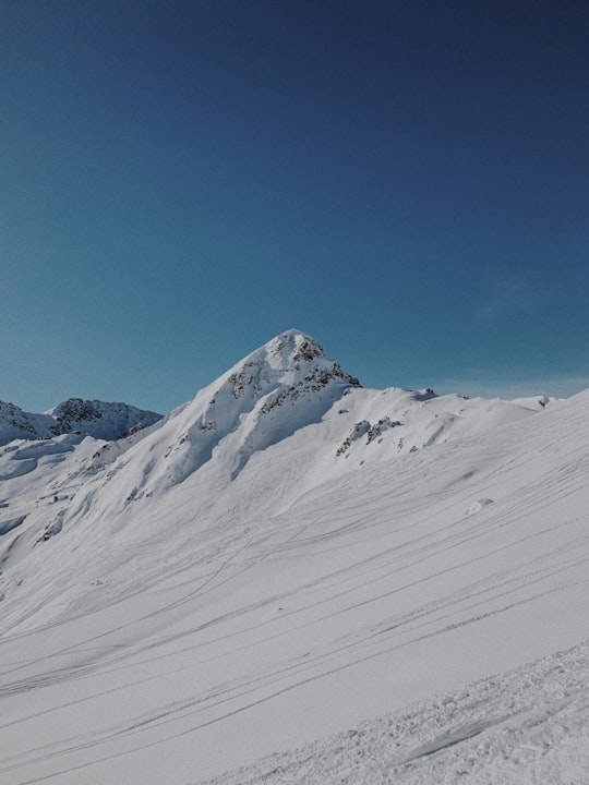 snow covered mountain under blue sky during daytime in Arosa Switzerland