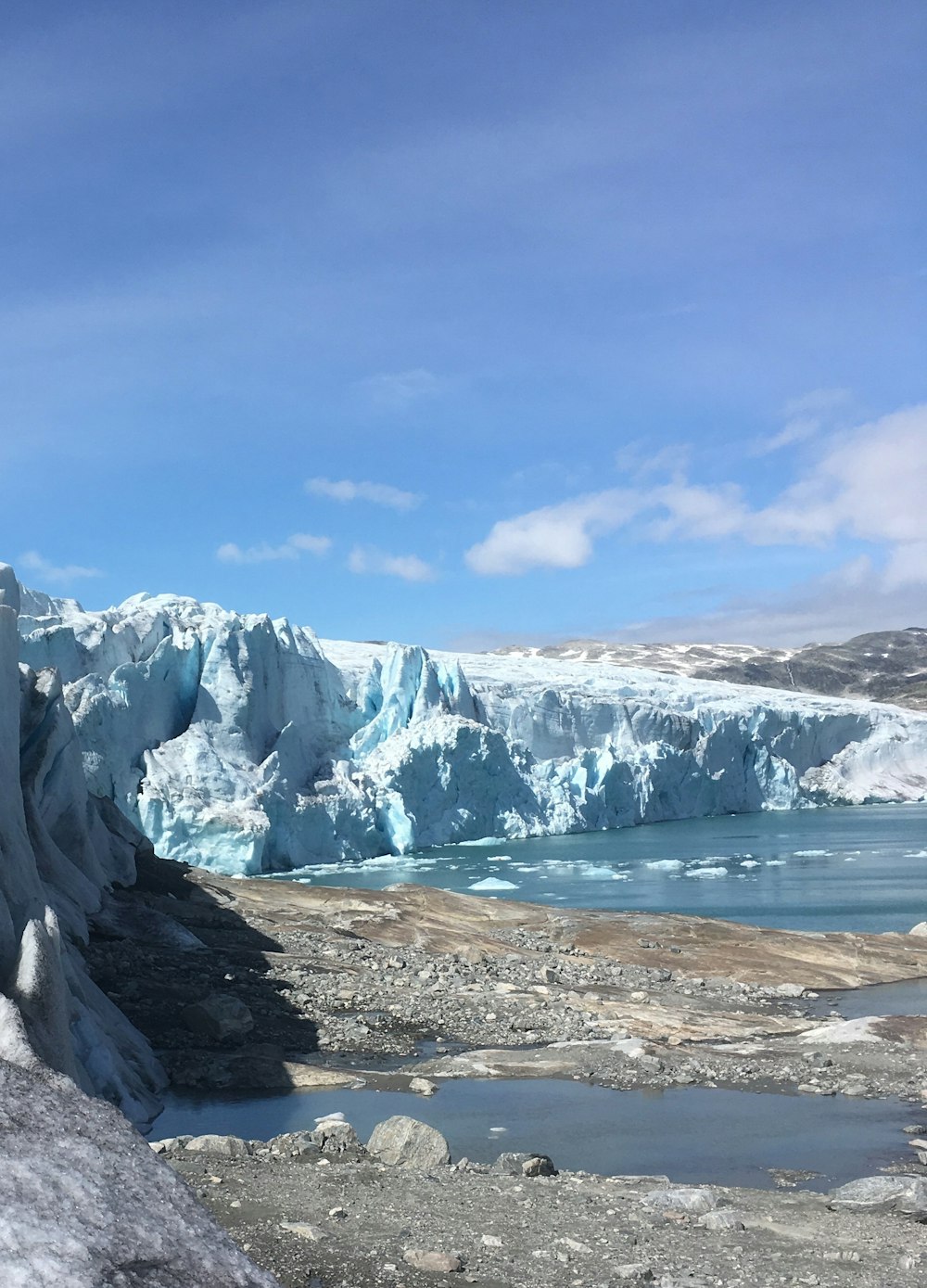 snow covered mountain near body of water during daytime