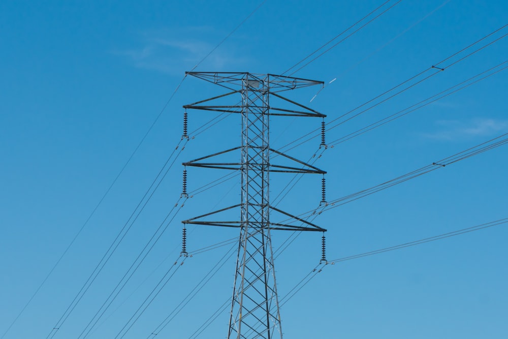 black electric post under blue sky during daytime