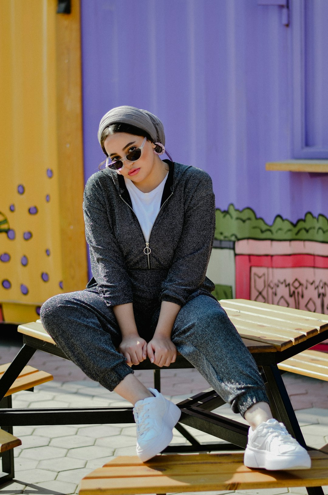 woman in blue cardigan sitting on brown wooden bench