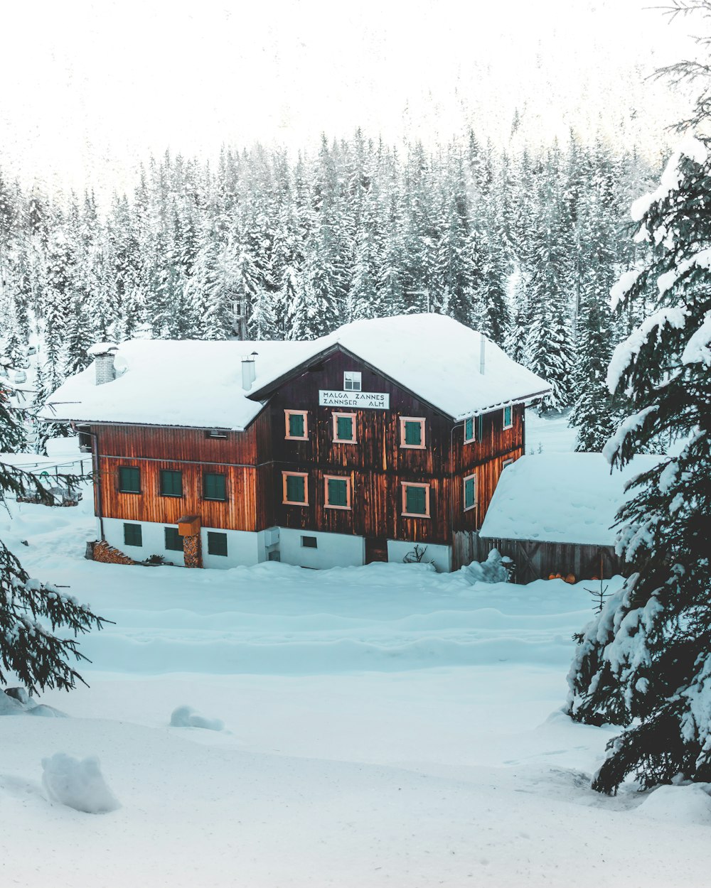 red and white wooden house on snow covered ground