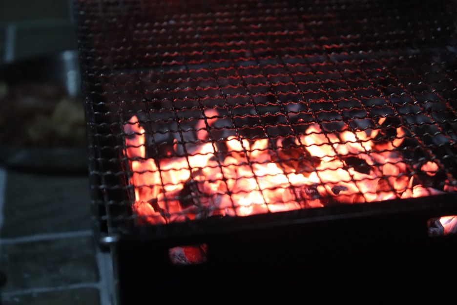 Close-up of glowing charcoal briquettes on a grill