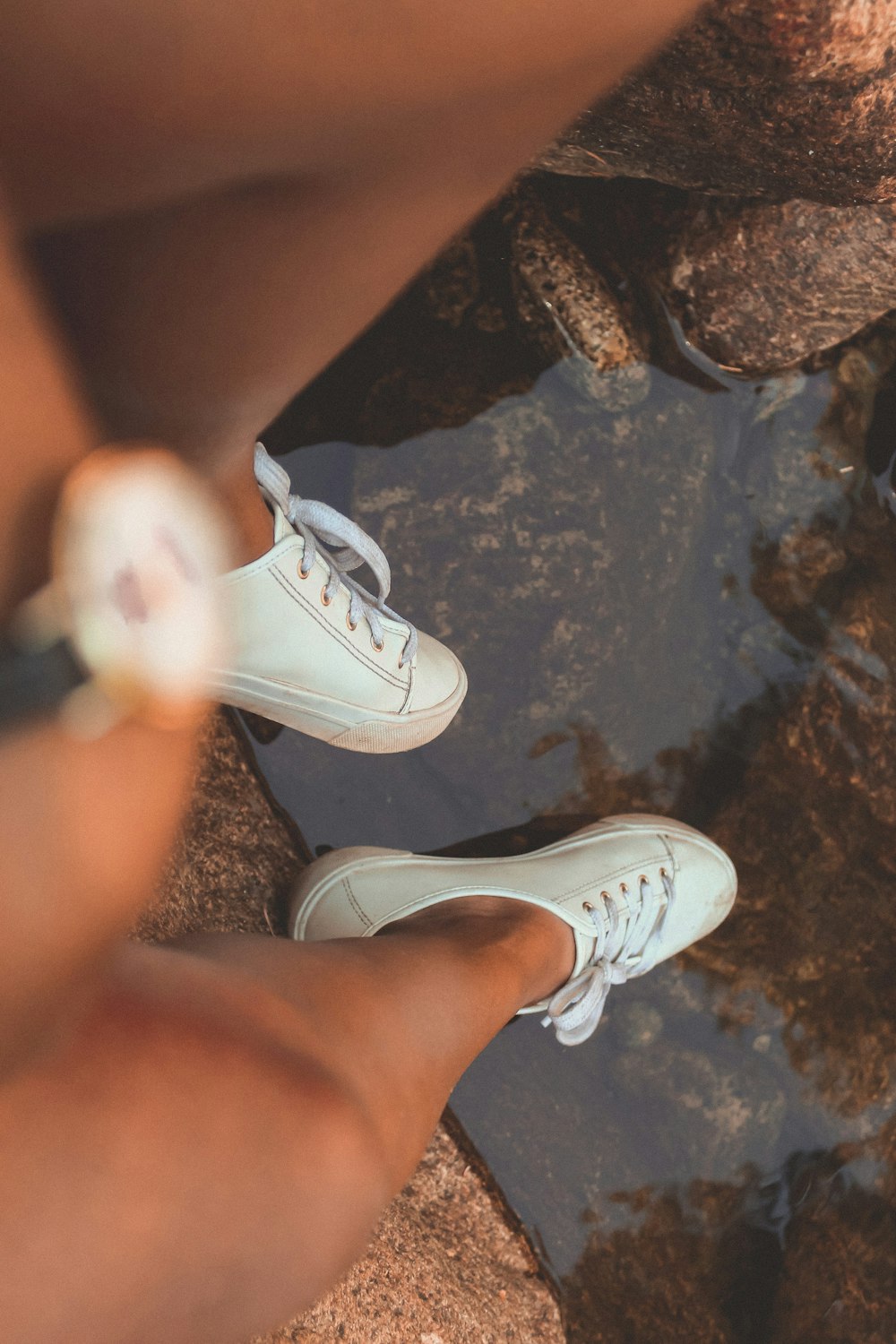 person wearing white low top sneakers