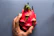 A smiling customer holding a ripe dragon fruit in a lush farm setting with green leaves around.