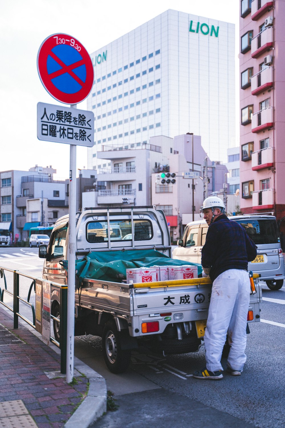 man in black jacket and blue denim jeans standing on the street during daytime