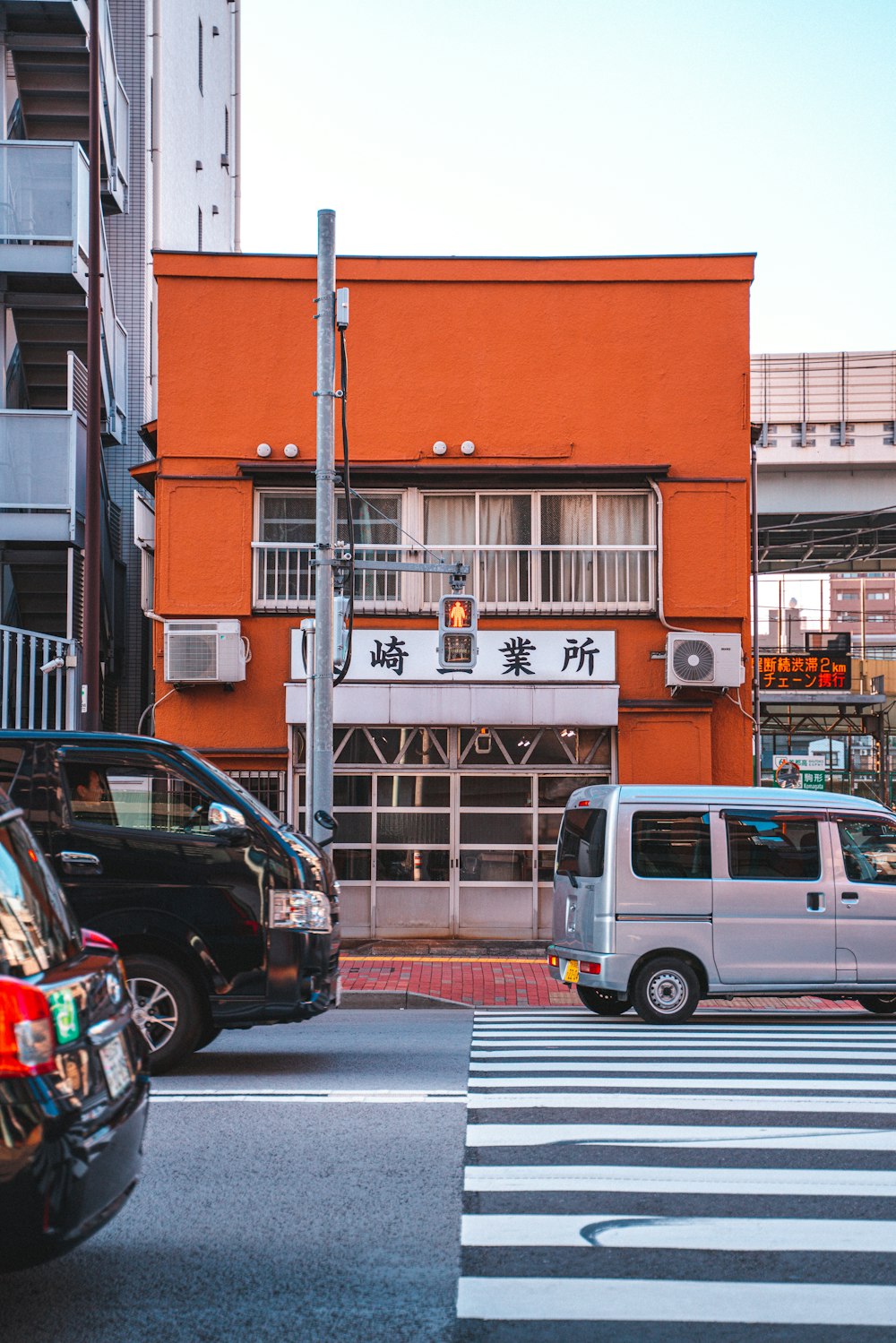 white van parked beside brown concrete building during daytime