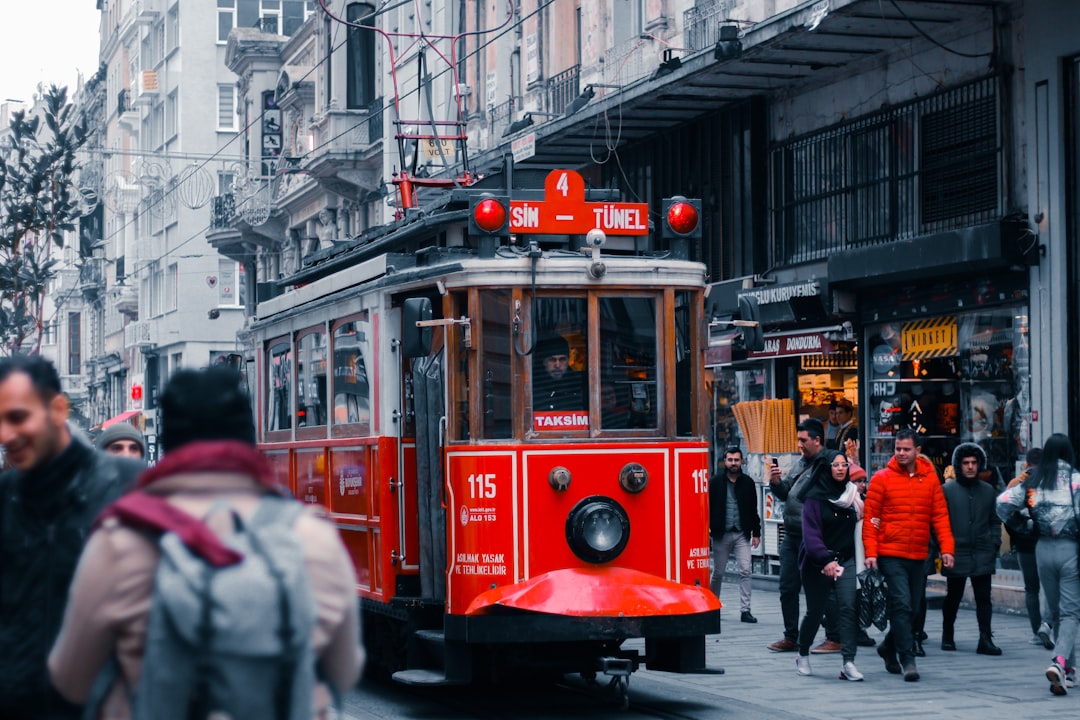 red tram on the street during daytime