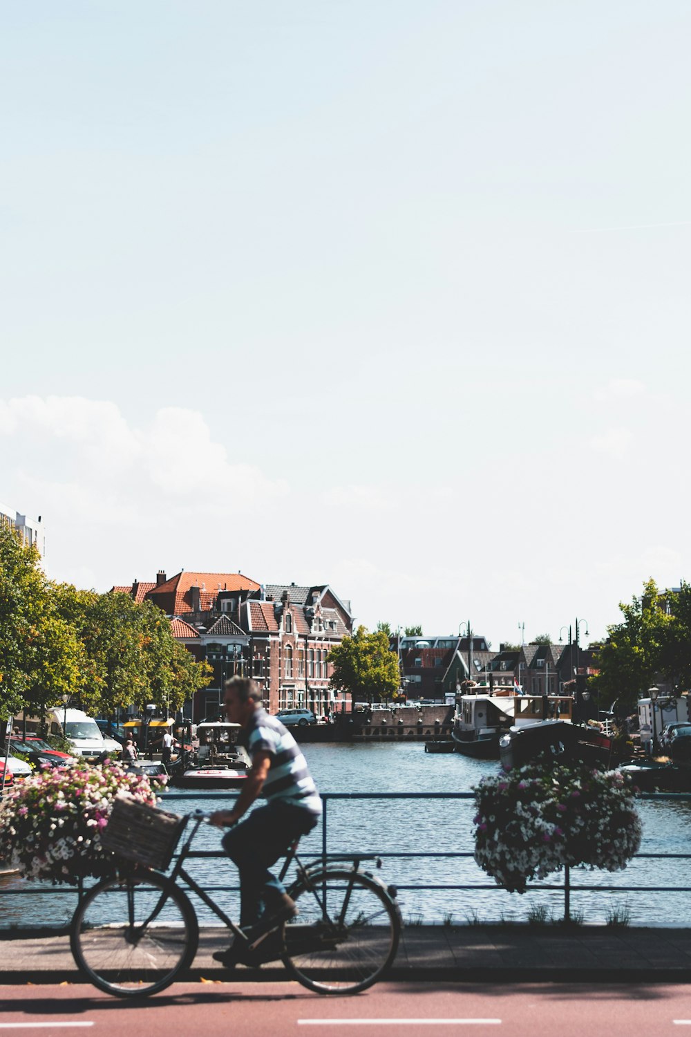 man in white shirt sitting on bench near river during daytime