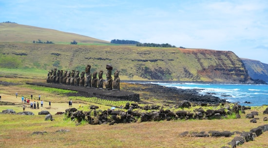 A group of tourists enjoying a guided tour of ancient stone statues on the island.