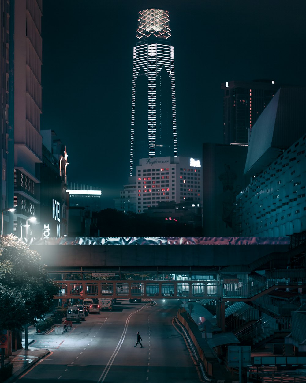 cars on road near high rise buildings during night time