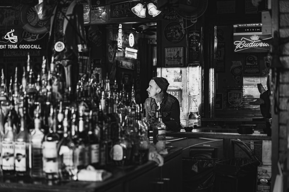 man in black and white long sleeve shirt standing near bar counter