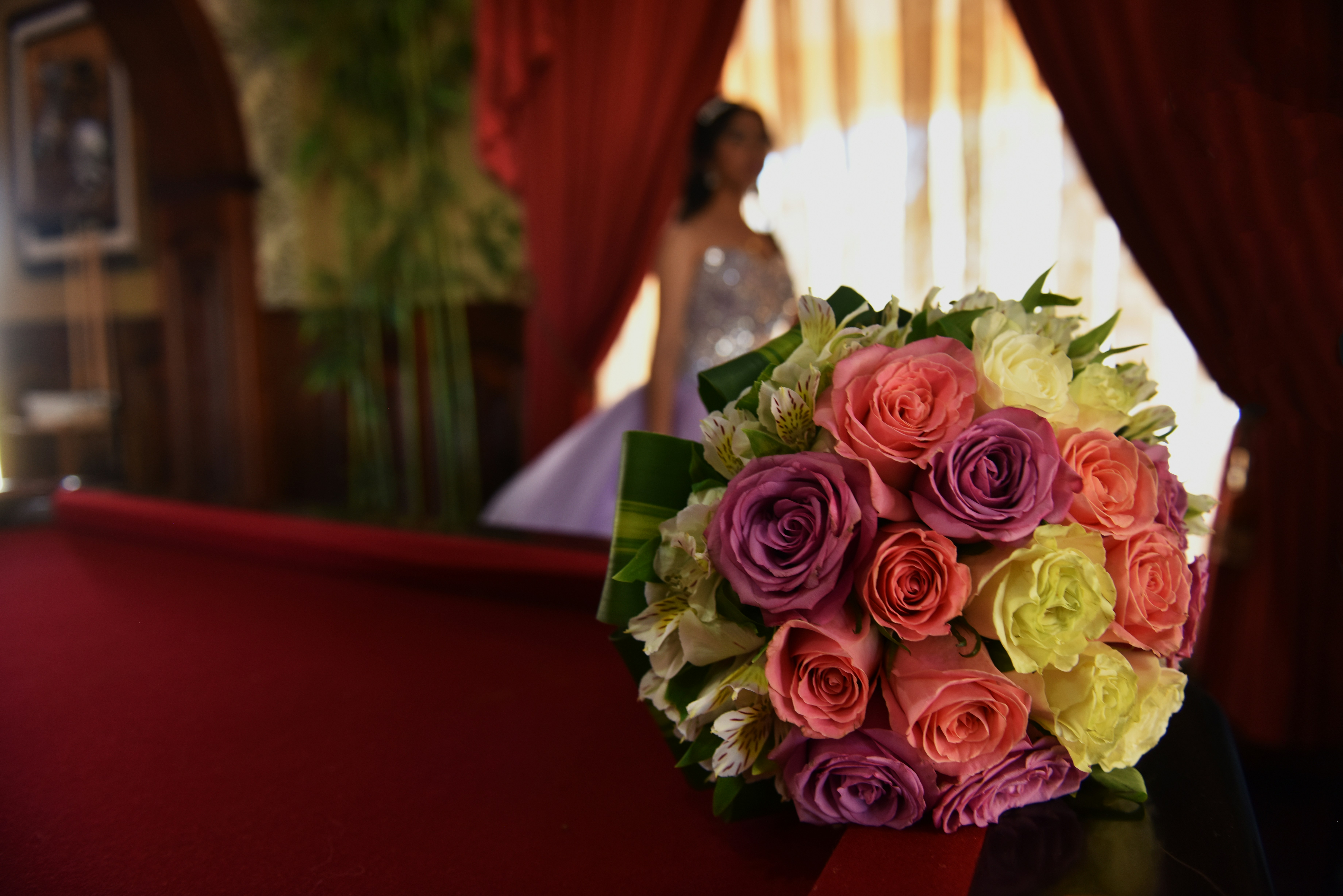 Mazzo di rose rosa su tavola rossa