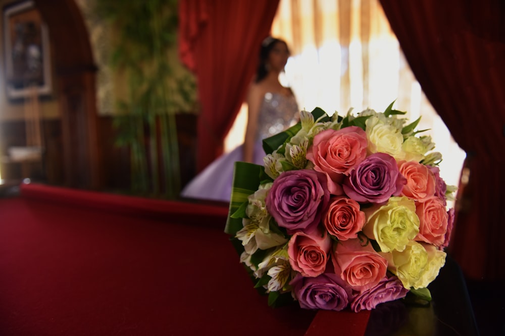 bouquet of pink roses on red table