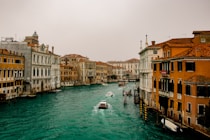 boat on water between buildings during daytime