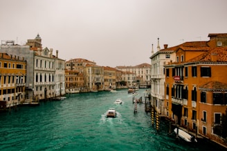 boat on water between buildings during daytime