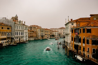 boat on water between buildings during daytime