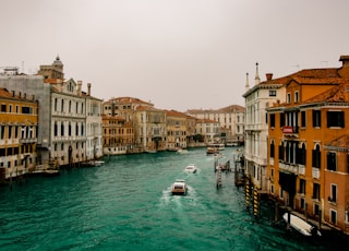 boat on water between buildings during daytime