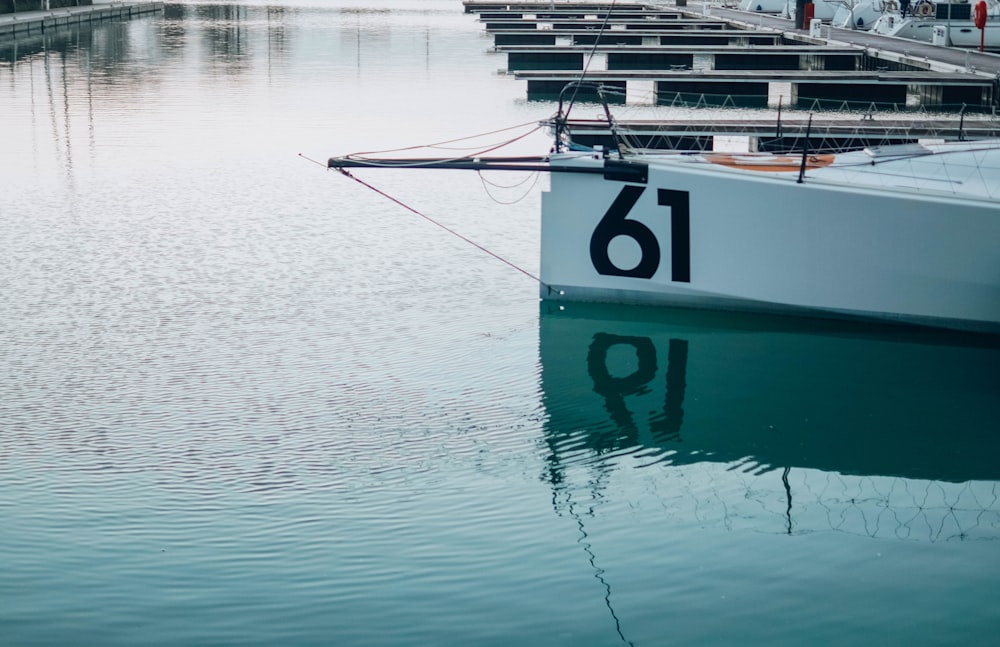 white and blue boat on body of water during daytime