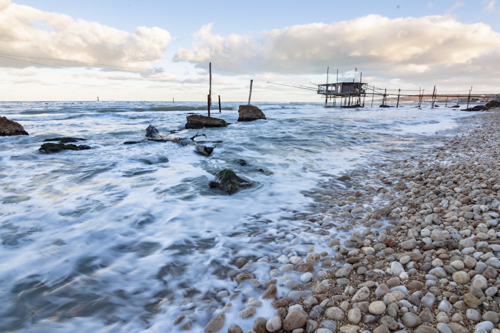 brown wooden dock on sea under blue sky during daytime